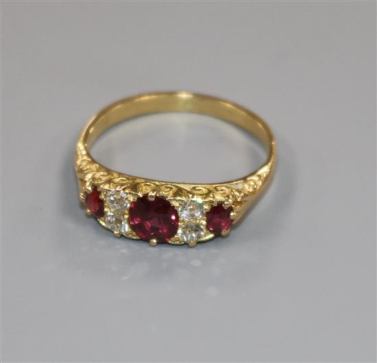 An early 20th century yellow metal, five stone ruby and diamond half hoop ring, size M.